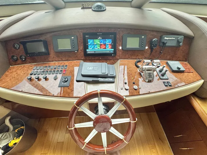  Yacht Photos Pics Helm of 2006 Marquis 65 yacht with navigation controls and wooden steering wheel.