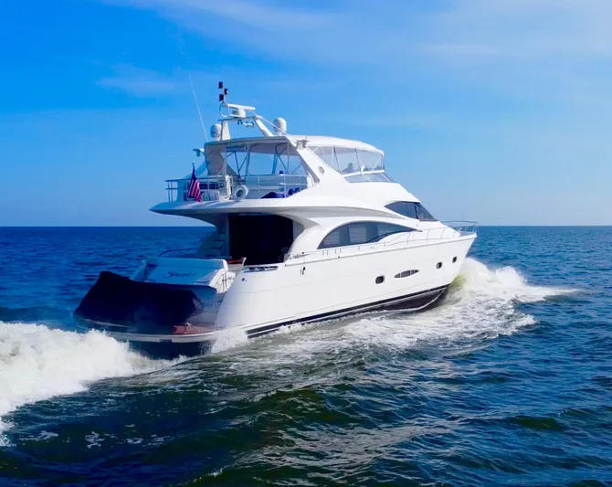  Yacht Photos Pics Luxurious 2006 Marquis 65 yacht cruising on open sea under clear blue sky.