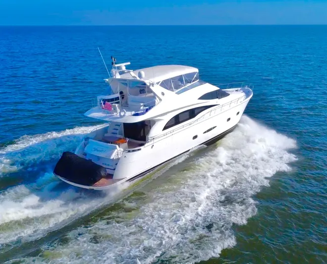  Yacht Photos Pics Luxury 2006 Marquis 65 yacht cruising on open sea under clear blue sky.