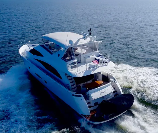  Yacht Photos Pics Luxurious 2006 Marquis 65 yacht cruising on open water, rear view.