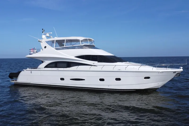  Yacht Photos Pics Luxury 2006 Marquis 65 yacht cruising on open water under clear blue sky.