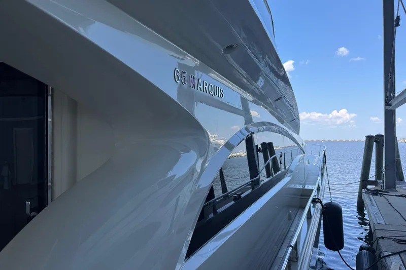  Yacht Photos Pics Luxury 2006 Marquis 65 yacht docked by the water on a sunny day.