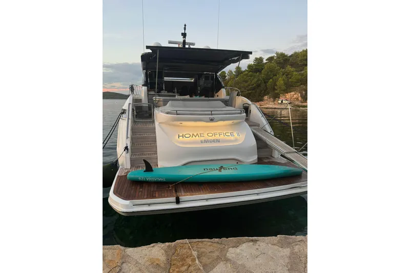 Home Office II Yacht Photos Pics 2023 Princess V60 yacht docked, featuring "Home Office II" signage and a paddleboard.