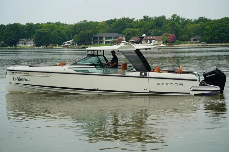  Yacht Photos Pics 2023 Saxdor 320 GTO boat cruising on a calm lake with lush green shoreline.