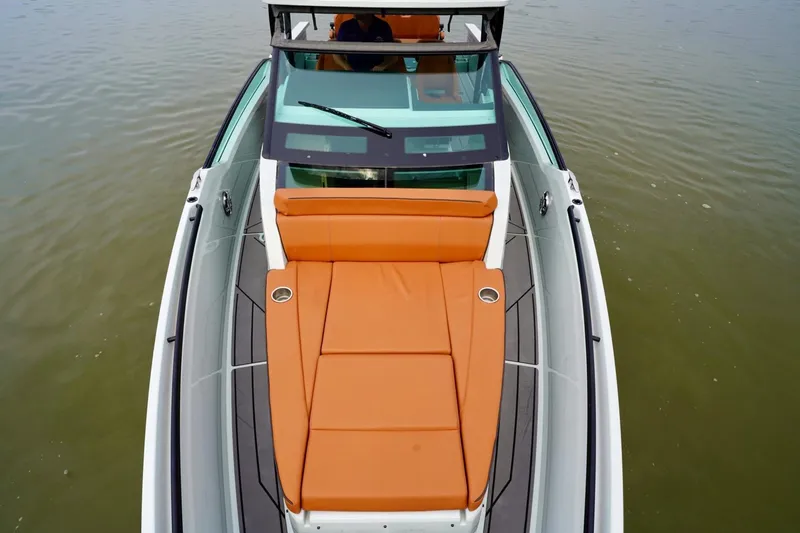  Yacht Photos Pics 2023 Saxdor 320 GTO boat with orange seating, viewed from above on calm water.