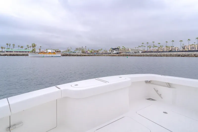 Champion Yacht Photos Pics 2022 Viking 38 Open Billfish boat on calm waters near a coastal cityscape.