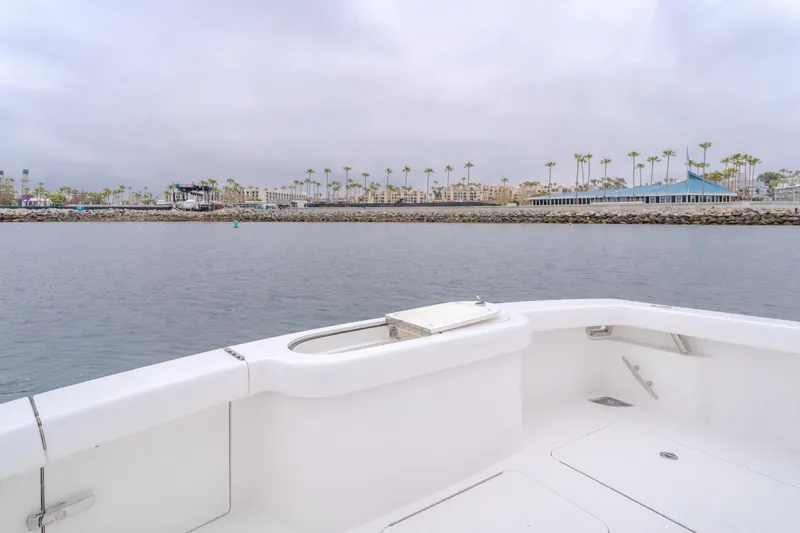 Champion Yacht Photos Pics 2022 Viking 38 Open Billfish boat on calm water near a coastal cityscape.