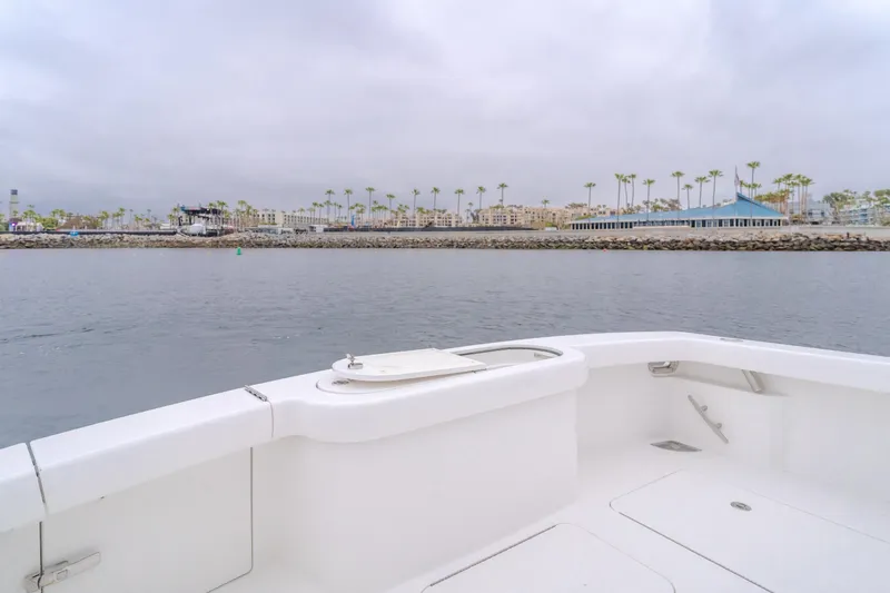 Champion Yacht Photos Pics 2022 Viking 38 Open Billfish boat on calm water near a coastal cityscape.