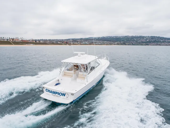 Champion Yacht Photos Pics 2022 Viking 38 Open Billfish cruising on the ocean near a coastal city.