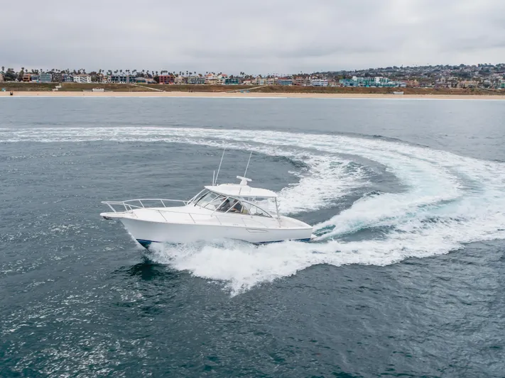 Champion Yacht Photos Pics 2022 Viking 38 Open Billfish cruising in open water near a coastal city.