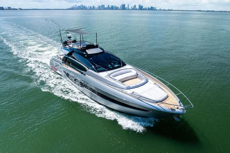 Dreaming Yacht Photos Pics Luxurious 2023 Riva 76 PERSEO Super yacht cruising on open water with city skyline backdrop.