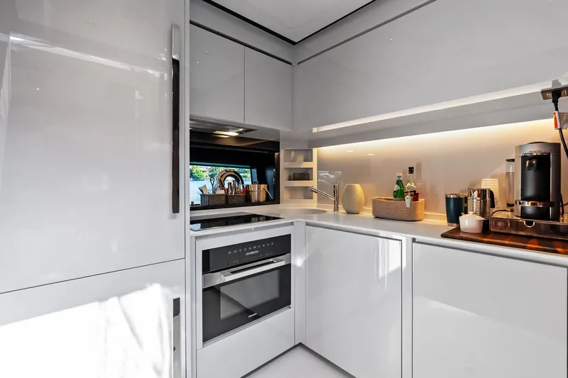 Dreaming Yacht Photos Pics Modern kitchen interior on 2023 Riva 76 PERSEO Super yacht, featuring sleek white cabinetry and appliances.