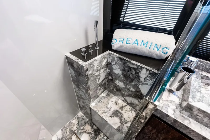 Dreaming Yacht Photos Pics Luxurious marble bathroom in 2023 Riva 76 PERSEO Super yacht, featuring elegant fixtures and "Dreaming" towel.