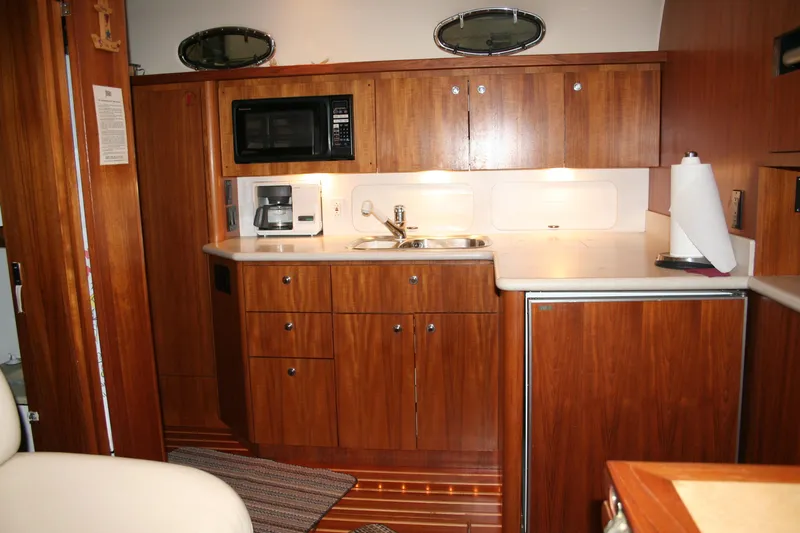  Yacht Photos Pics 2001 Tiara Yachts 4000 Express galley with wood cabinetry, microwave, and sink.