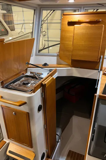  Yacht Photos Pics Interior of 2021 Sargo 25 boat with wooden cabinetry and compact kitchen area.