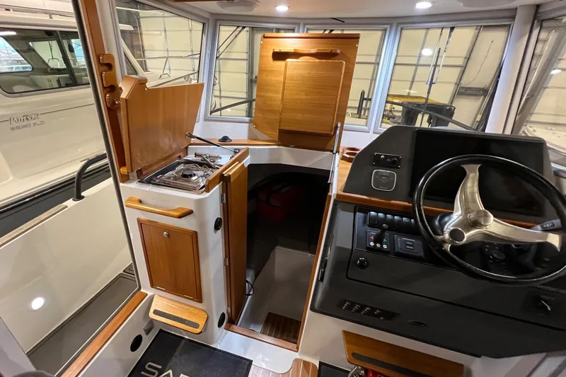  Yacht Photos Pics Interior of a 2021 Sargo 25 boat with steering wheel and kitchenette.