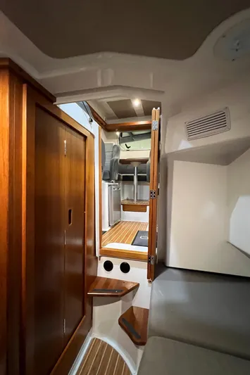  Yacht Photos Pics Interior of 2021 Sargo 25 boat with wooden cabinetry and seating area.