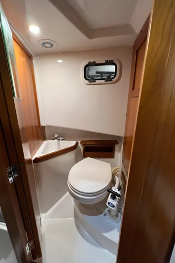  Yacht Photos Pics Compact bathroom in 2021 Sargo 25 boat with toilet, sink, and porthole window.