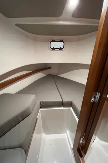  Yacht Photos Pics Interior cabin of a 2021 Sargo 25 boat with cushioned seating and a small window.