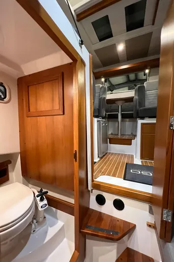  Yacht Photos Pics Interior of 2021 Sargo 25 boat with wooden finishes and compact bathroom.
