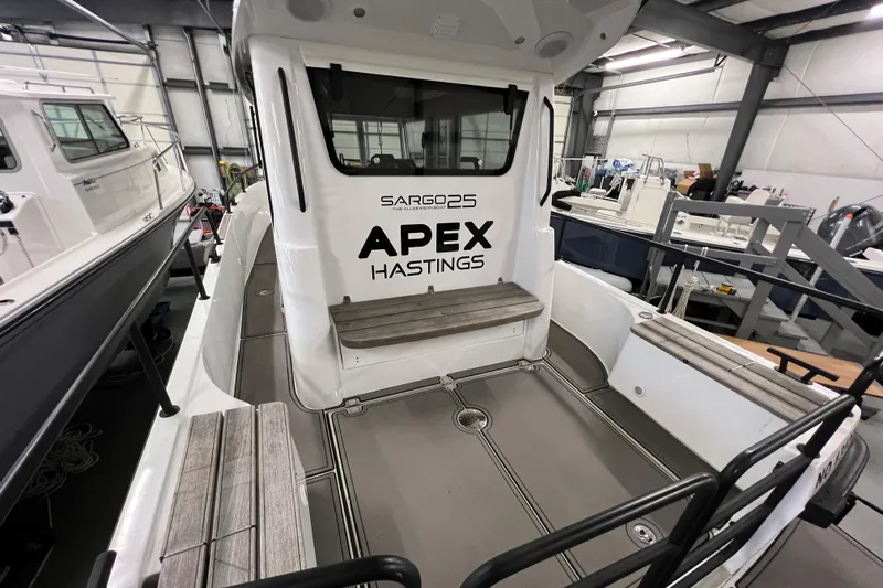  Yacht Photos Pics 2021 Sargo 25 boat interior with seating, labeled APEX HASTINGS, in a storage facility.