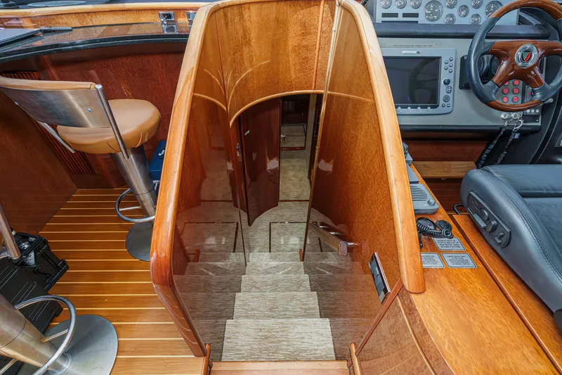 Compass Rose Yacht Photos Pics Interior of 2006 Fairline 74 Custom yacht, featuring wooden stairs and modern helm controls.