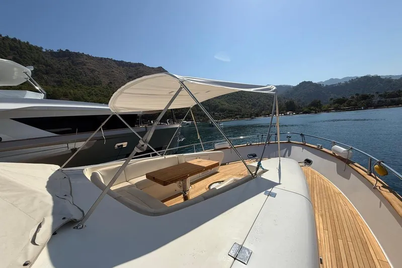  Yacht Photos Pics 2008 Evo Marine Deauville 76 yacht deck with canopy, wooden table, and scenic water view.