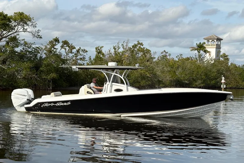  Yacht Photos Pics 2012 Nor-Tech 340 Sport Center Console boat cruising on calm water near lush greenery.