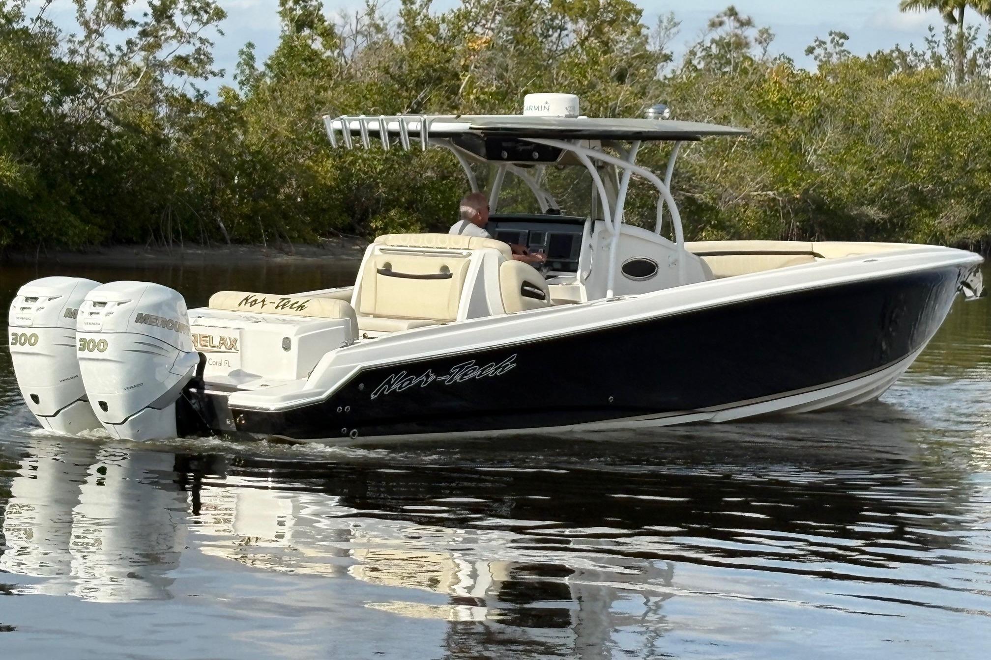 2012 Nor-Tech 340 Sport Center Console boat cruising on calm water.