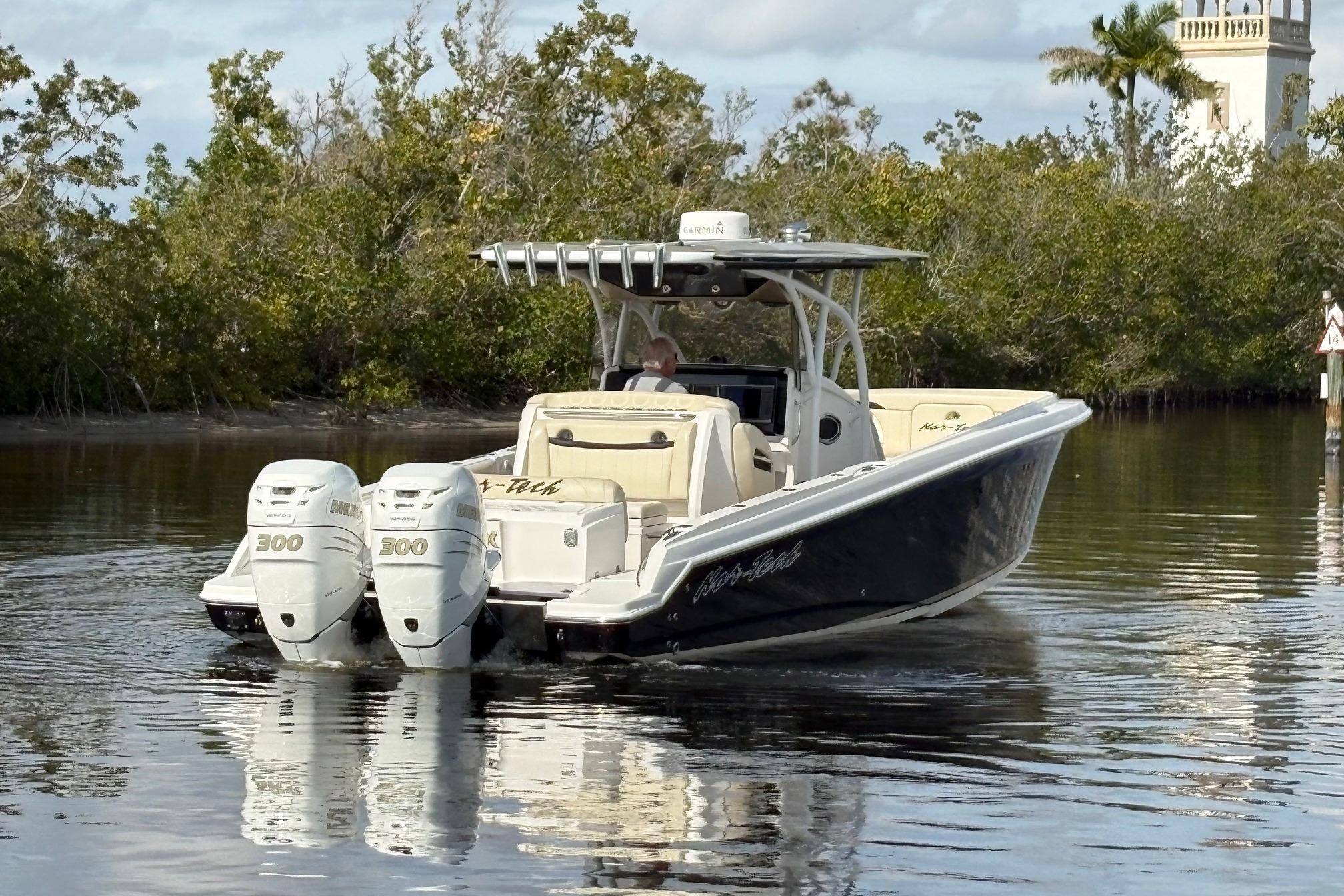 2012 Nor-Tech 340 Sport Center Console boat with twin 300 engines on calm water.