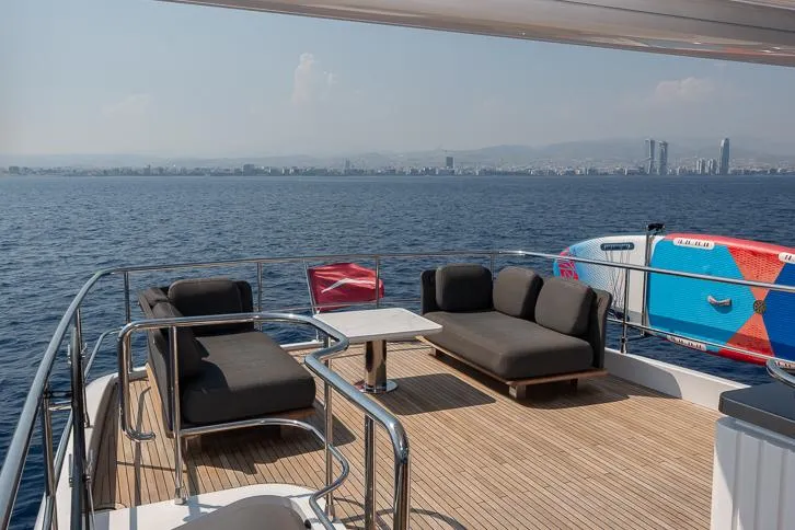 Grey T Yacht Photos Pics Azimut Magellano 66 yacht deck with seating, ocean view, and city skyline in the background.
