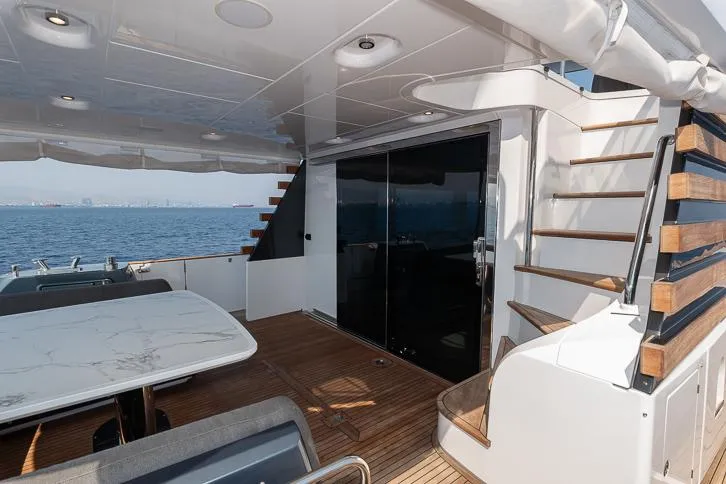 Grey T Yacht Photos Pics Azimut Magellano 66 yacht deck with seating, table, and stairs, 2021 model.