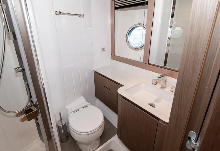 Grey T Yacht Photos Pics Luxurious bathroom on 2021 Azimut Magellano 66 yacht with modern fixtures and porthole window.