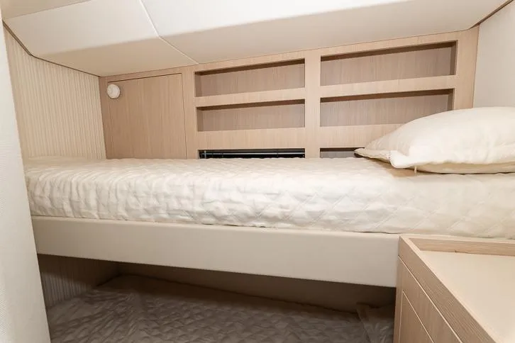 Grey T Yacht Photos Pics Interior cabin of 2021 Azimut Magellano 66 yacht with bunk beds and wooden shelving.