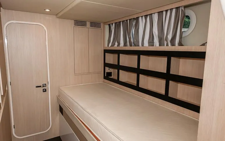 Grey T Yacht Photos Pics Interior cabin of 2021 Azimut Magellano 66 yacht with bed and storage shelves.