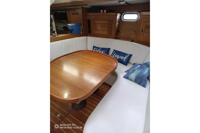 Mandala Yacht Photos Pics Interior of 2002 Catalina 42 MkII sailboat with wooden table and cozy seating.