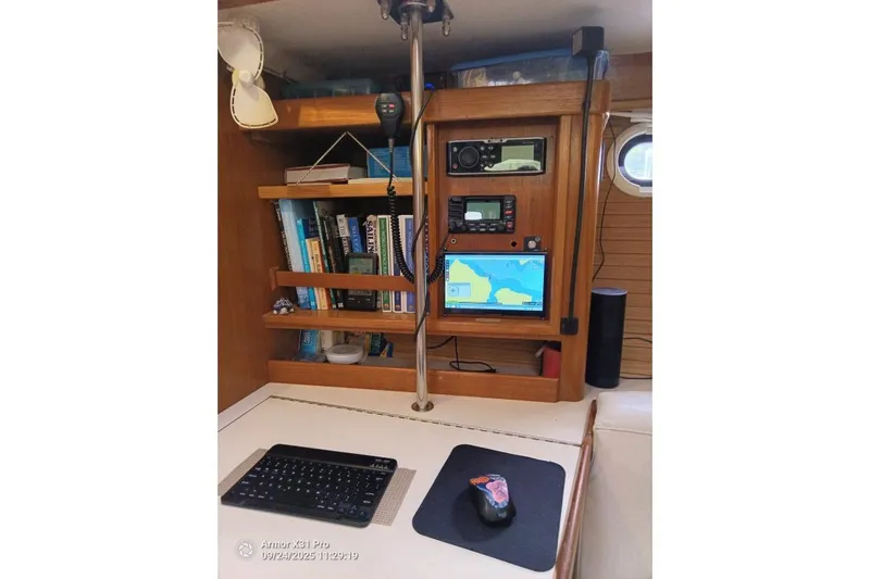 Mandala Yacht Photos Pics Navigation station on a 2002 Catalina 42 MkII sailboat with electronics and books.