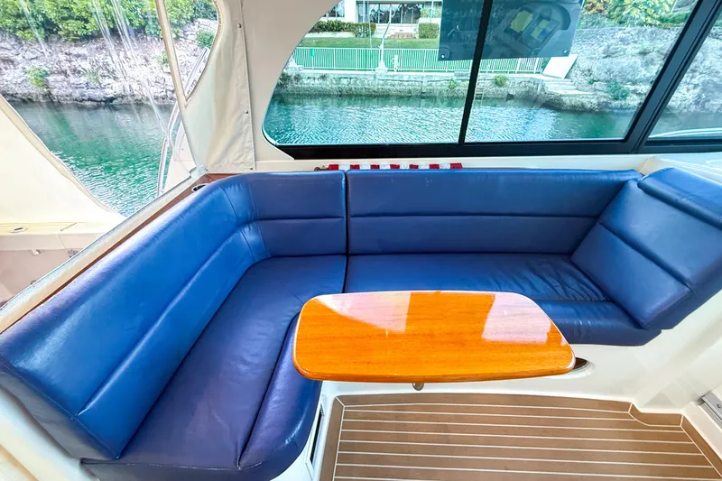  Yacht Photos Pics Luxurious seating area on 2021 Hinckley Sport Boats 40x with blue cushions and wooden table.