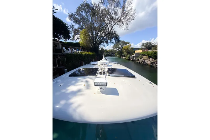 Yacht Photos Pics 2021 Hinckley Sport Boats 40x cruising through a scenic, tree-lined canal.