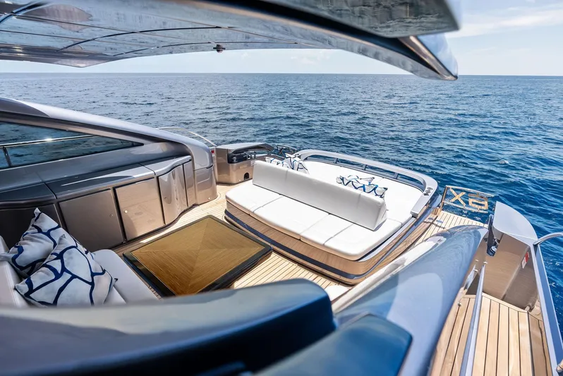 Our Trade Yacht Photos Pics Luxurious 2024 Pershing 6X yacht deck with elegant seating, overlooking the ocean.
