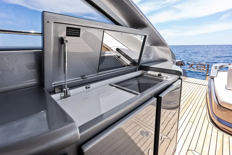 Our Trade Yacht Photos Pics 2024 Pershing 6X yacht deck with sleek outdoor kitchen and ocean view.