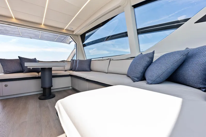 Our Trade Yacht Photos Pics Luxurious interior of 2024 Pershing 6X yacht with modern seating and panoramic windows.