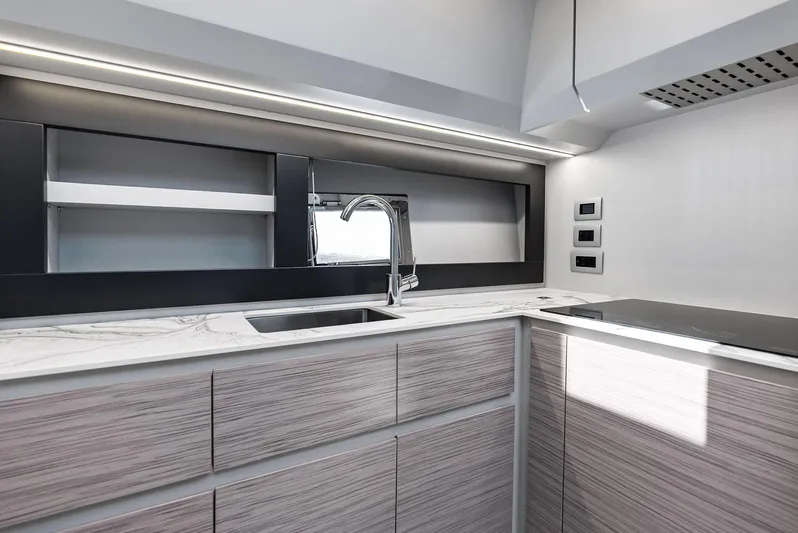 Our Trade Yacht Photos Pics Modern kitchen interior of 2024 Pershing 6X yacht with sleek design and marble countertops.