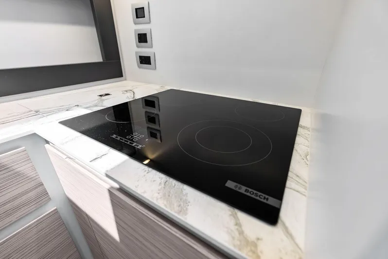 Our Trade Yacht Photos Pics Modern Bosch cooktop on marble countertop in 2024 Pershing 6X yacht kitchen.