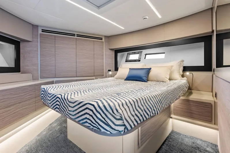 Our Trade Yacht Photos Pics Luxurious bedroom interior of 2024 Pershing 6X yacht with modern design and striped bedding.