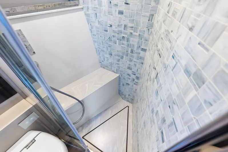 Our Trade Yacht Photos Pics Luxurious bathroom in 2024 Pershing 6X yacht with elegant tiled walls and modern fixtures.