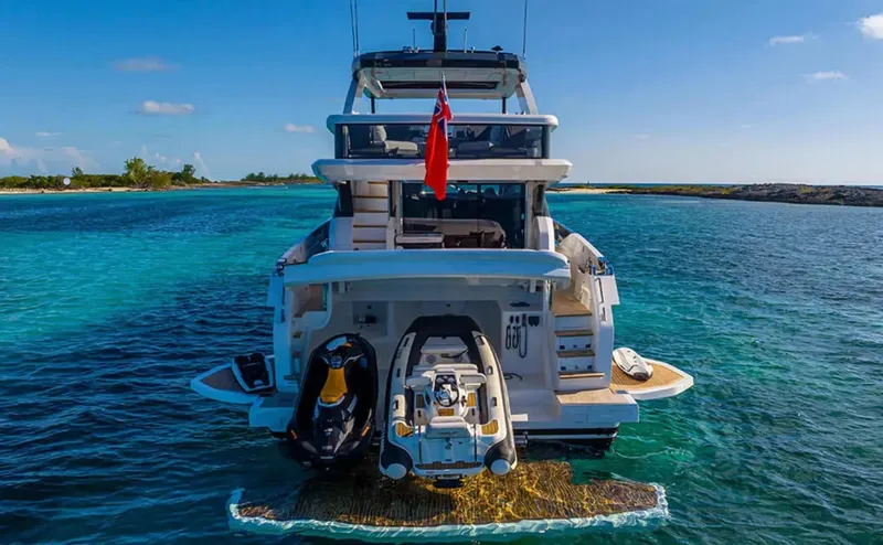  Yacht Photos Pics 2025 Pearl 72 yacht on clear blue water, rear view with jet ski and tender.