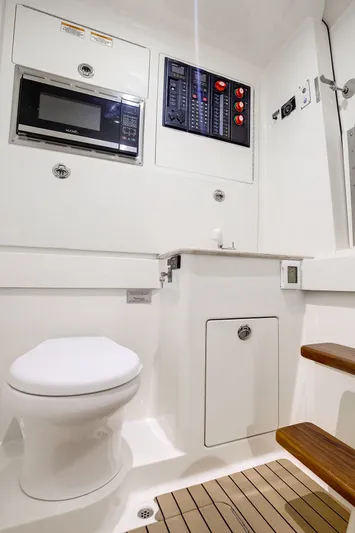 China Girl Yacht Photos Pics 2020 Valhalla V-41 boat interior with toilet, microwave, and control panel.