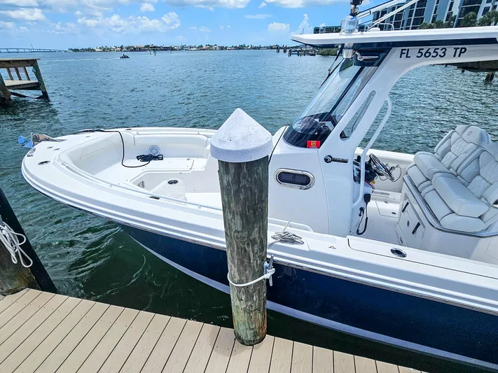  Yacht Photos Pics 2023 Edgewater 262CC boat docked at marina, clear skies, calm water.