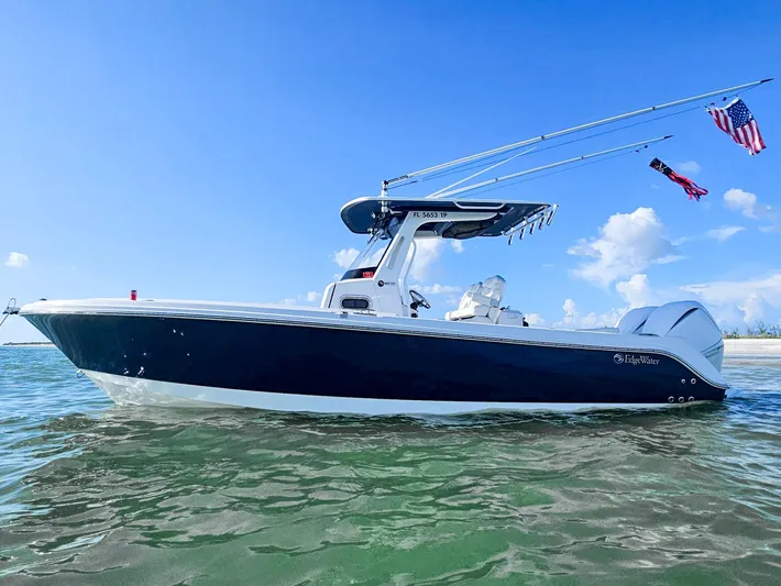  Yacht Photos Pics 2023 Edgewater 262CC boat on water, clear sky, flags flying, side view.